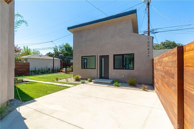 10943 Pickford Way, Culver City, CA 90230 - view of front facade with fence, a patio, stucco siding, and a front lawn