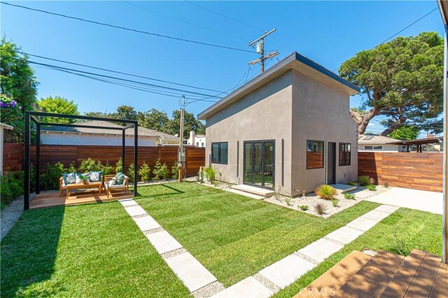 10943 Pickford Way, Culver City, CA 90230 - back of property featuring a yard, an outdoor living space, a fenced backyard, and stucco siding