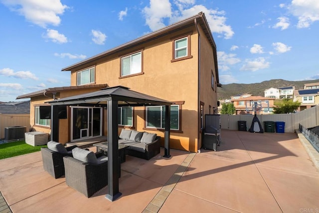 rear view of property featuring an outdoor living space, stucco siding, a gazebo, central air condition unit, and a patio area