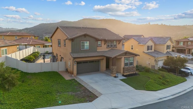 view of front of property featuring fence, a mountain view, a residential view, concrete driveway, and a garage