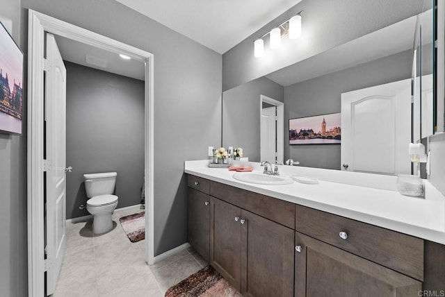 bathroom featuring tile patterned floors, baseboards, toilet, and vanity