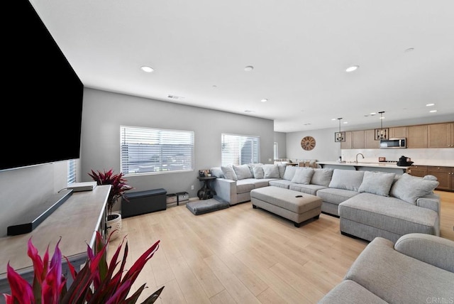 living area with visible vents, recessed lighting, and light wood-style floors