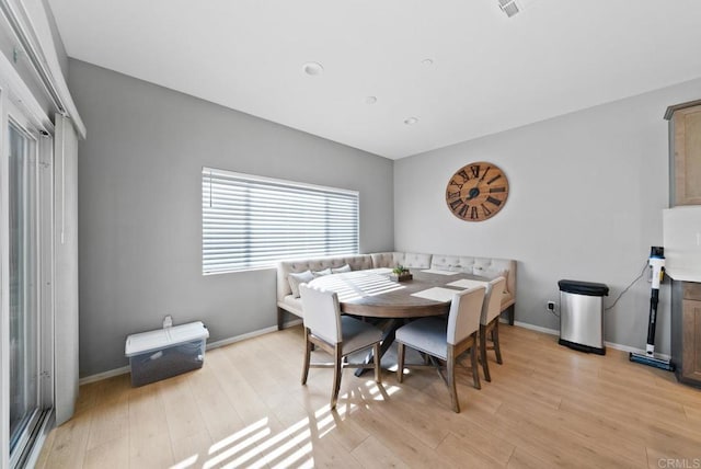 dining space featuring baseboards and light wood finished floors