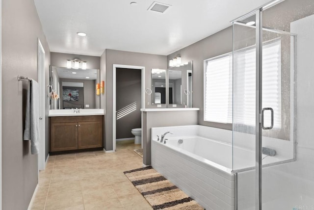 bathroom with vanity, toilet, visible vents, and a stall shower