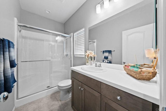 bathroom featuring vanity, tile patterned floors, toilet, and a stall shower