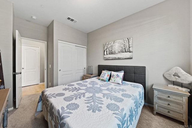 bedroom with visible vents, baseboards, carpet, and a closet