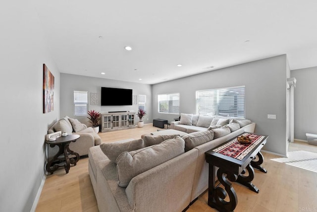 living room with light wood finished floors, recessed lighting, and baseboards