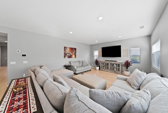 living area with recessed lighting, visible vents, and light wood finished floors