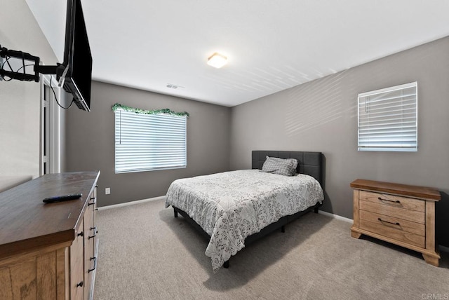 bedroom with light carpet, visible vents, and baseboards