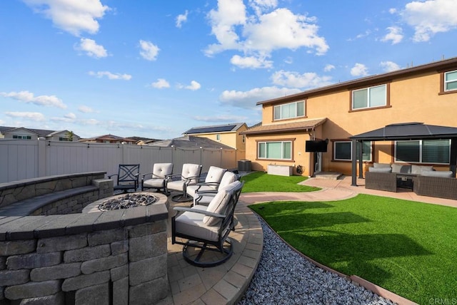 view of patio with central AC unit, an outdoor living space with a fire pit, and fence