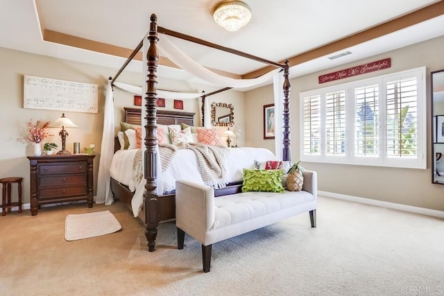 carpeted bedroom with a tray ceiling, visible vents, and baseboards