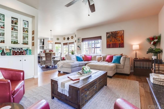 living room with wood finished floors and ceiling fan