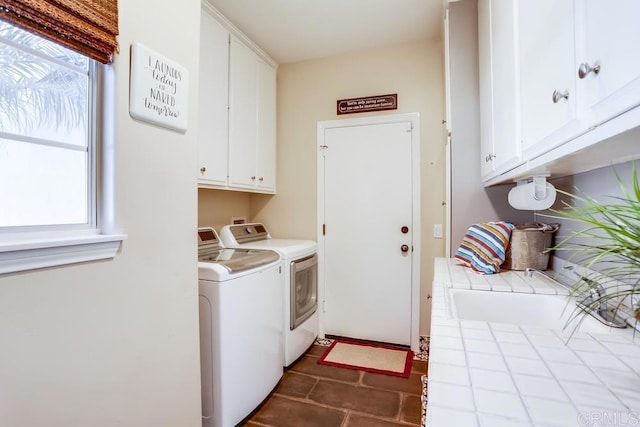 laundry room featuring cabinet space, washer and dryer, and dark tile patterned flooring