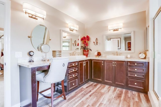 bathroom featuring double vanity, wood finished floors, and a sink