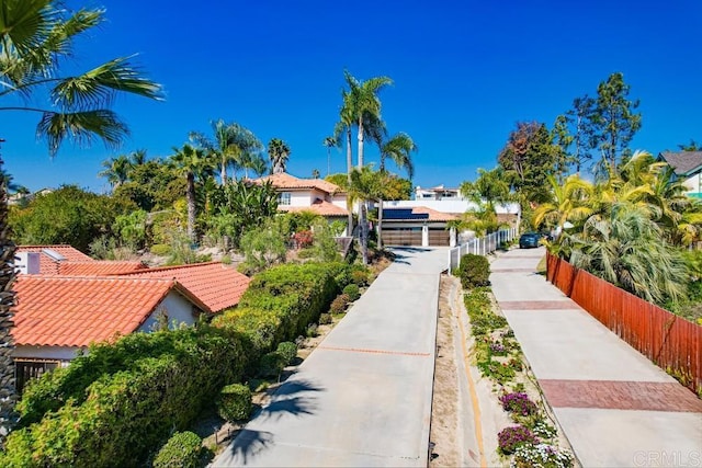 exterior space featuring a tile roof and fence