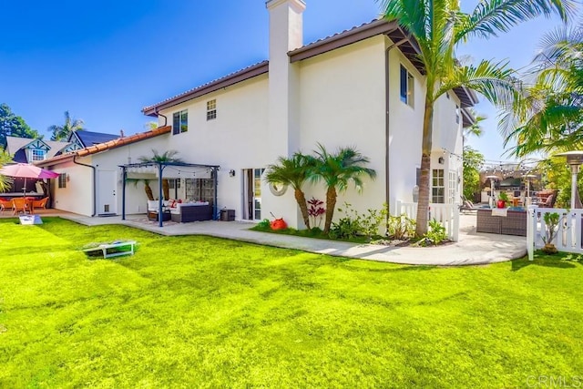 back of property featuring stucco siding, an outdoor hangout area, a lawn, a pergola, and a patio