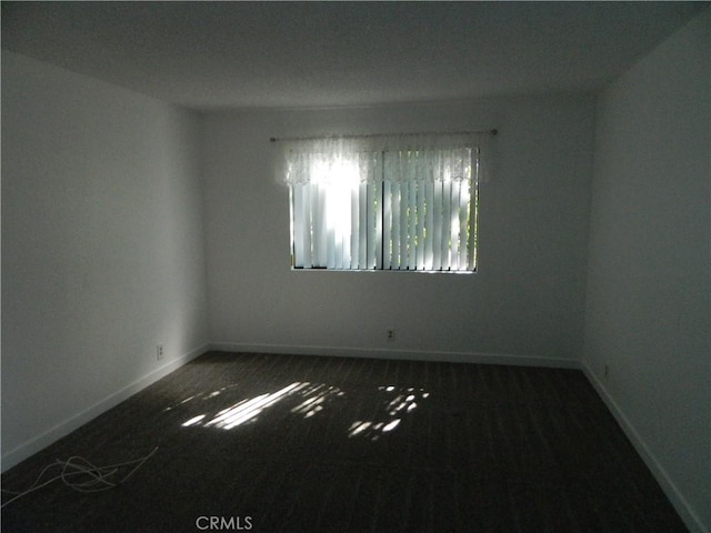 unfurnished room featuring baseboards