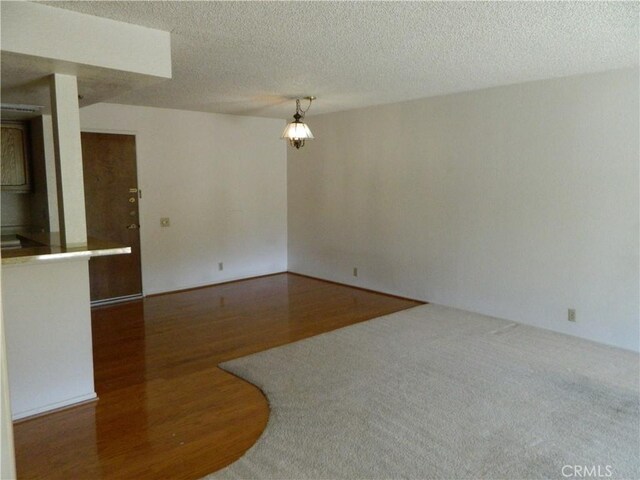 spare room with wood finished floors and a textured ceiling