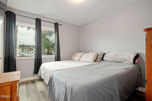 bedroom featuring dark wood-type flooring and baseboards