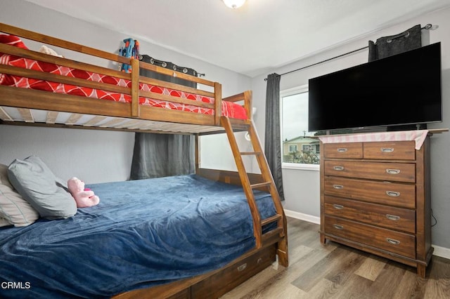 bedroom featuring baseboards and wood finished floors