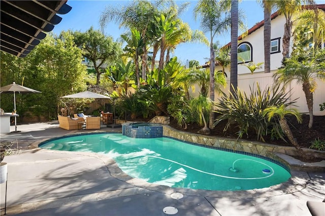 view of pool featuring an outdoor living space, fence, a pool with connected hot tub, and a patio area