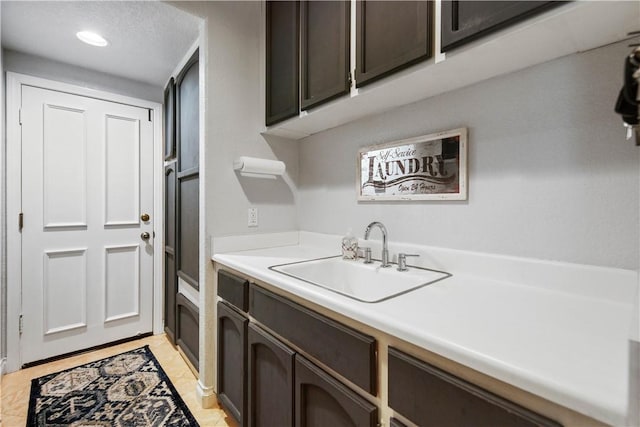 laundry area featuring light tile patterned floors and a sink