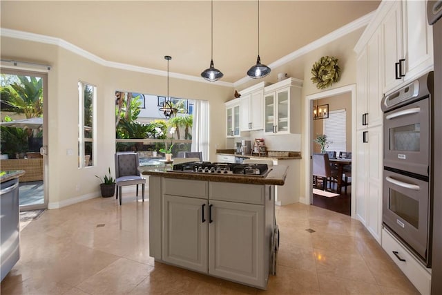 kitchen featuring dark countertops, a center island, an inviting chandelier, white cabinets, and stainless steel appliances