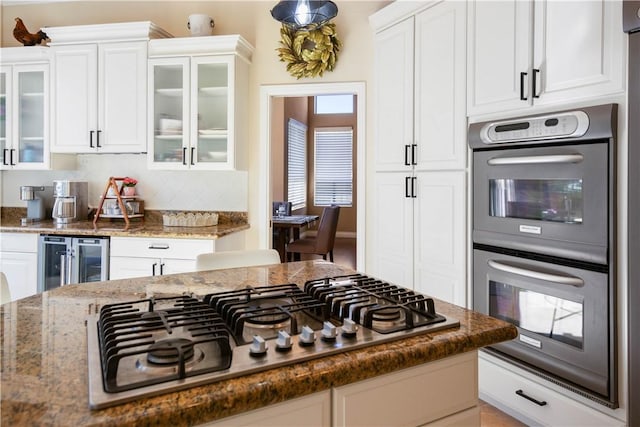 kitchen with white cabinetry, wine cooler, double oven, and stainless steel gas cooktop