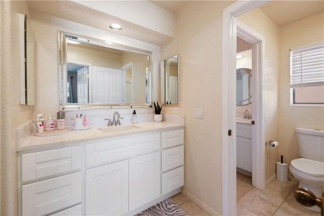 bathroom with vanity, tile patterned floors, toilet, and baseboards