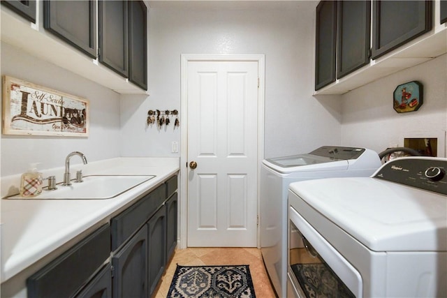 laundry area with washing machine and dryer, light tile patterned flooring, cabinet space, and a sink