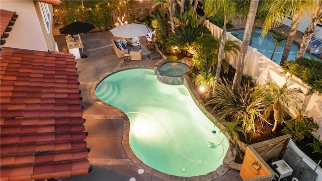 view of pool with a pool with connected hot tub, a fenced backyard, and a patio area