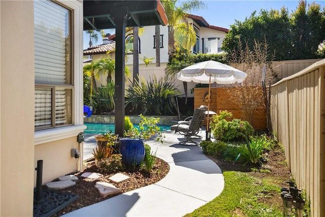 view of yard featuring a patio area, an outdoor pool, and a fenced backyard