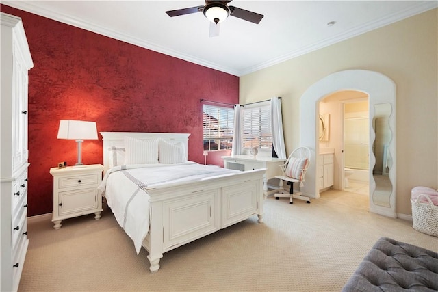 bedroom with an accent wall, baseboards, light colored carpet, ornamental molding, and arched walkways