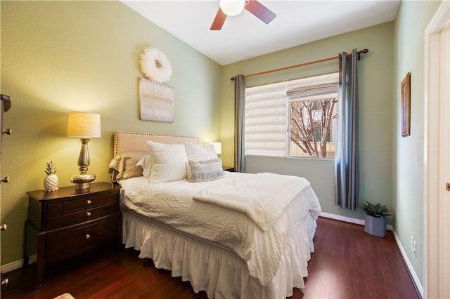 bedroom with dark wood finished floors, a ceiling fan, and baseboards