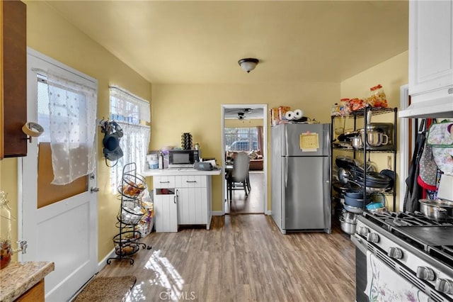 kitchen featuring white cabinetry, light countertops, light wood finished floors, and stainless steel appliances