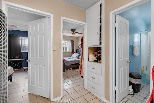 hall featuring light tile patterned flooring and a textured ceiling