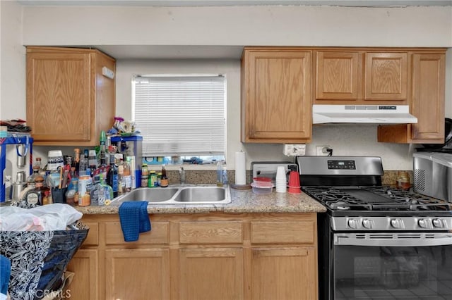 kitchen with under cabinet range hood, stainless steel gas range oven, and a sink