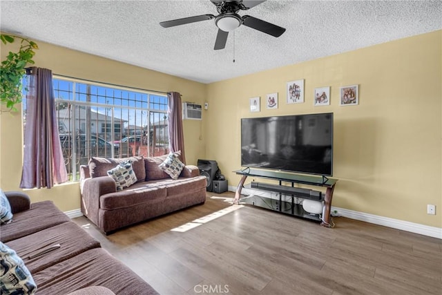 living area with wood finished floors, baseboards, and a textured ceiling