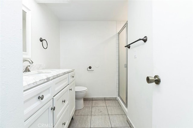 bathroom with vanity, tile patterned floors, toilet, and a stall shower