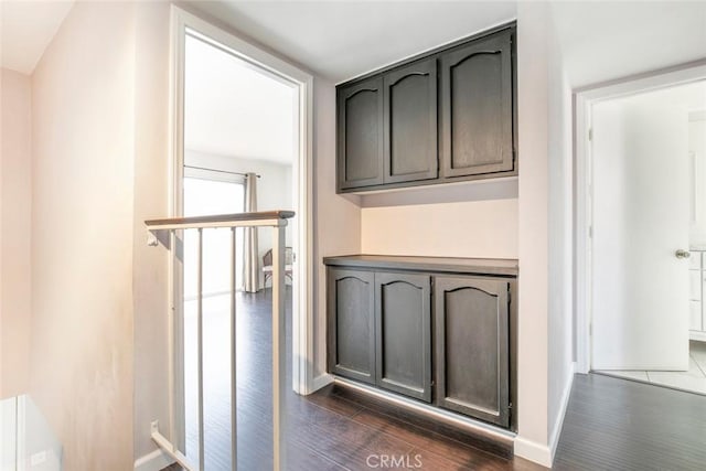 hall with dark wood-style floors and baseboards