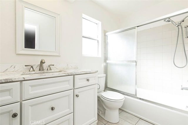 full bath featuring tile patterned floors, enclosed tub / shower combo, toilet, and vanity