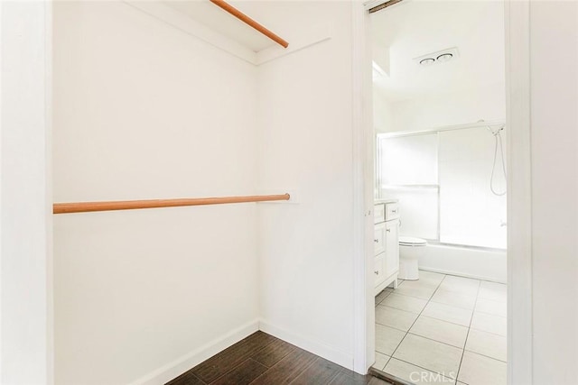 walk in closet with visible vents and wood finished floors