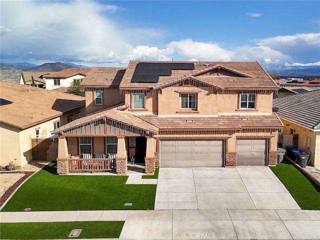 view of front facade featuring a tile roof, roof mounted solar panels, covered porch, stucco siding, and an attached garage