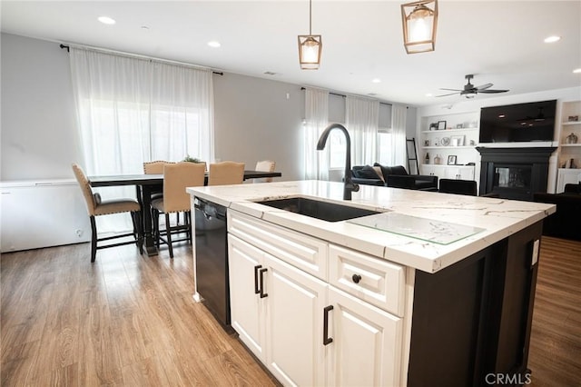 kitchen with dishwasher, ceiling fan, light wood-type flooring, and a sink