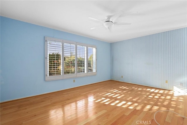 spare room featuring ceiling fan, wood finished floors, and ornamental molding