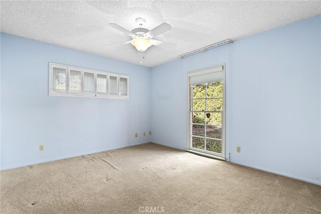 spare room with carpet floors, a textured ceiling, and a ceiling fan