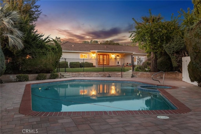 view of swimming pool with a patio area, fence, and a pool with connected hot tub