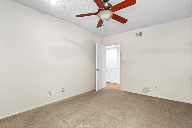 unfurnished room featuring visible vents, a textured ceiling, a ceiling fan, and carpet floors