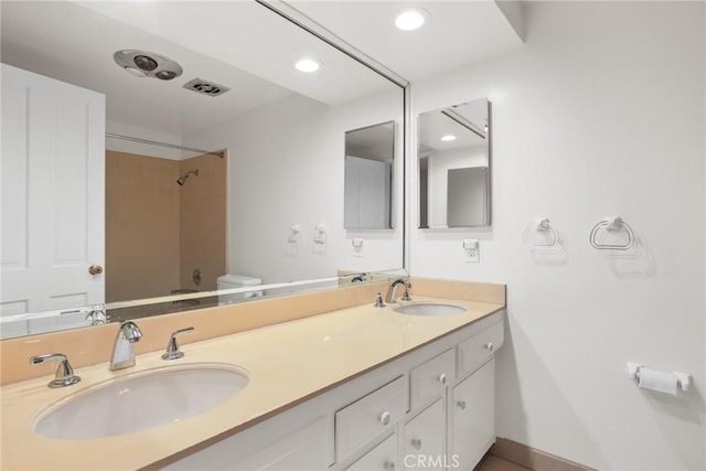 full bathroom featuring a sink, toilet, walk in shower, and recessed lighting