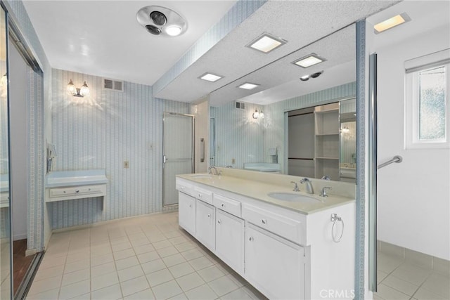 full bath with a sink, visible vents, tile patterned floors, and wallpapered walls